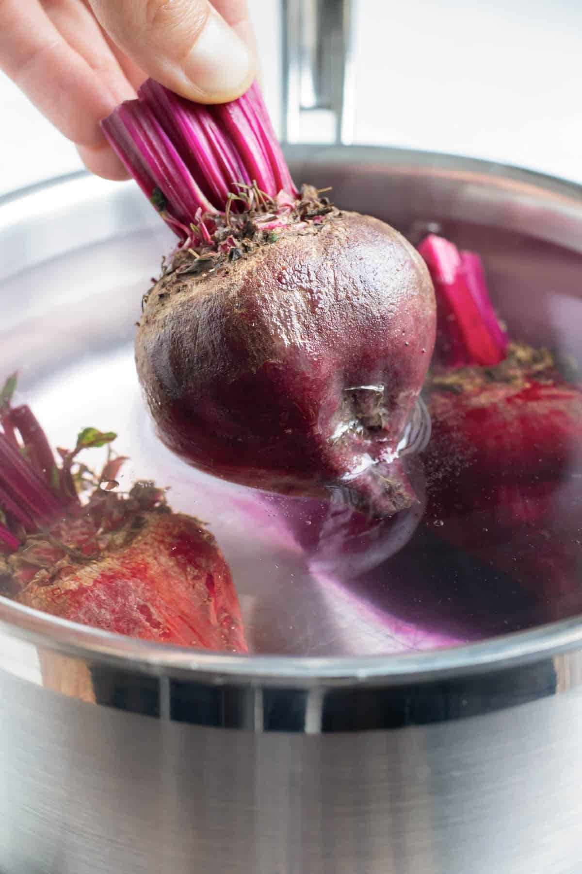 Beets are removed from the pot of water after being boiled.