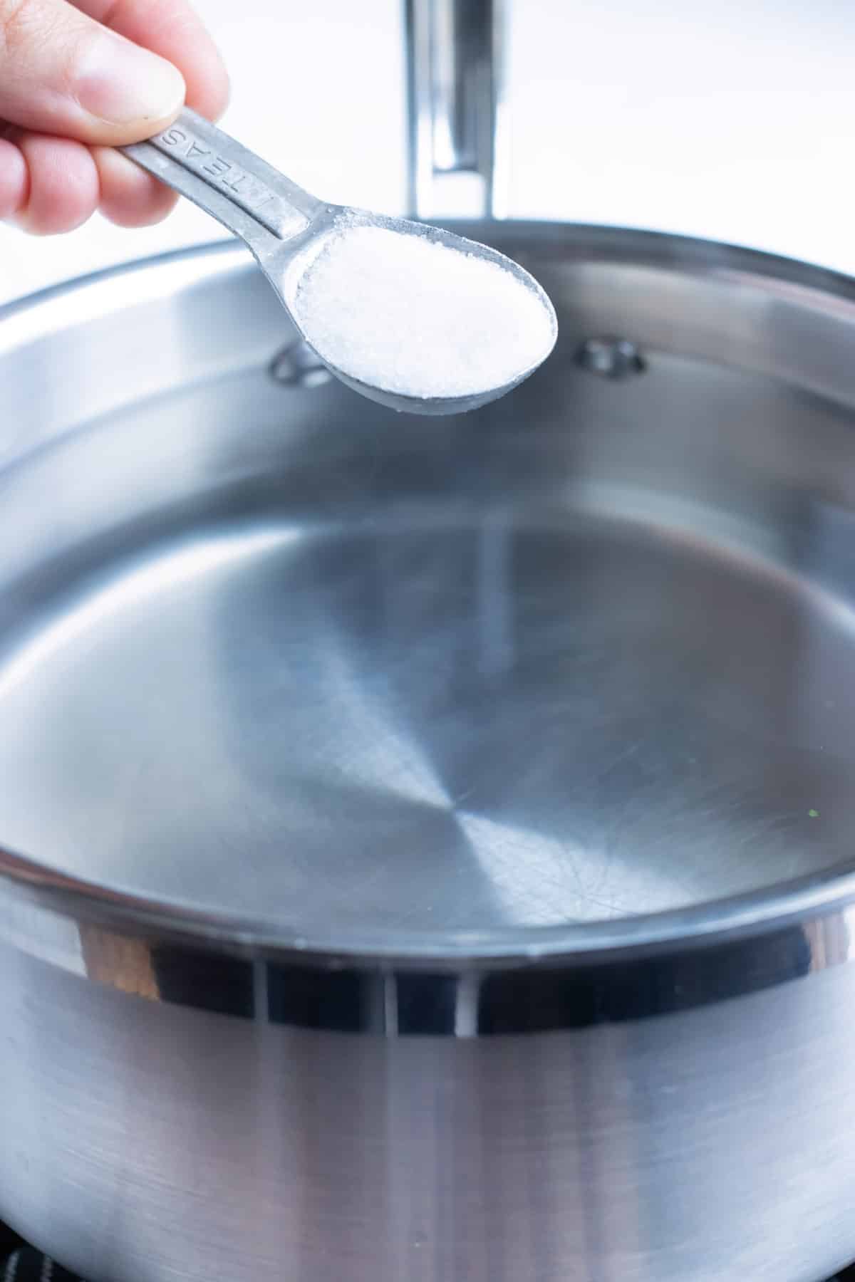 Water and salt are combined in a pot.