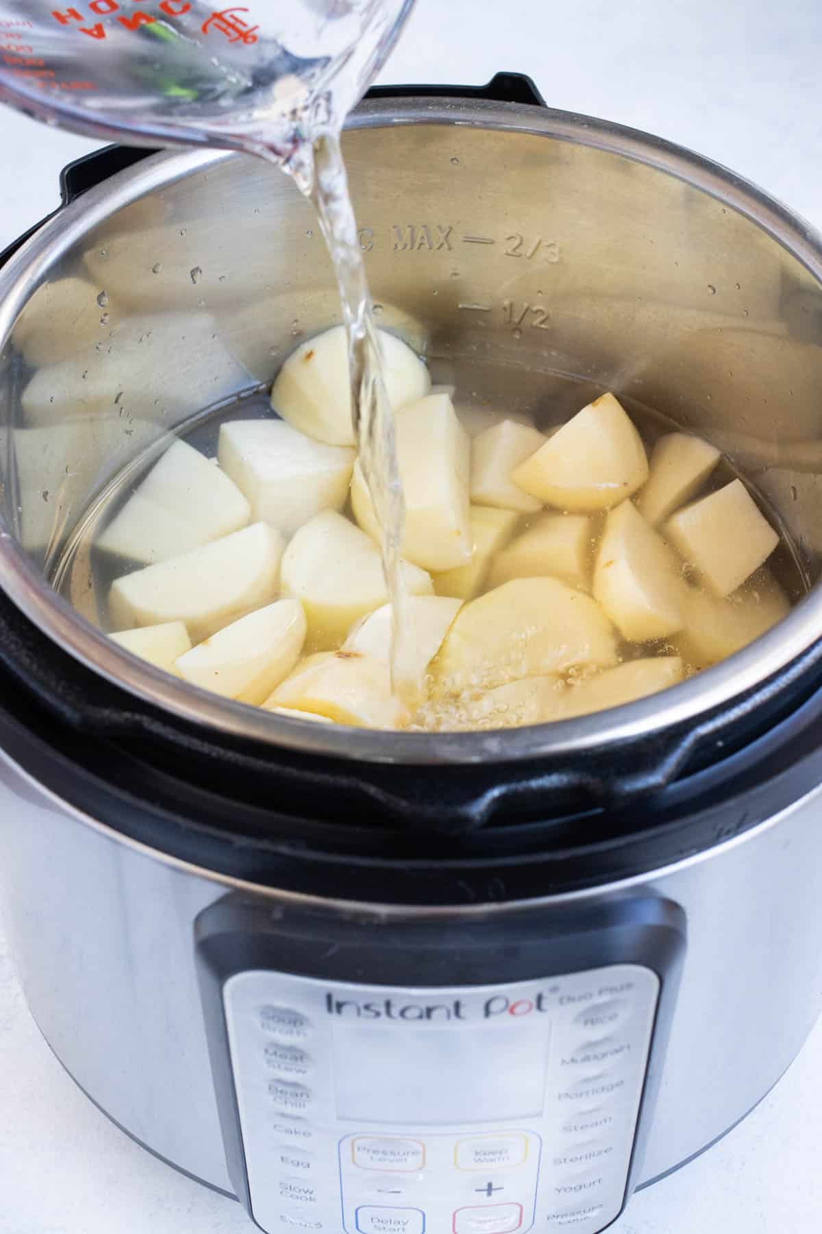 Potatoes and water are added to an Instant Pot.