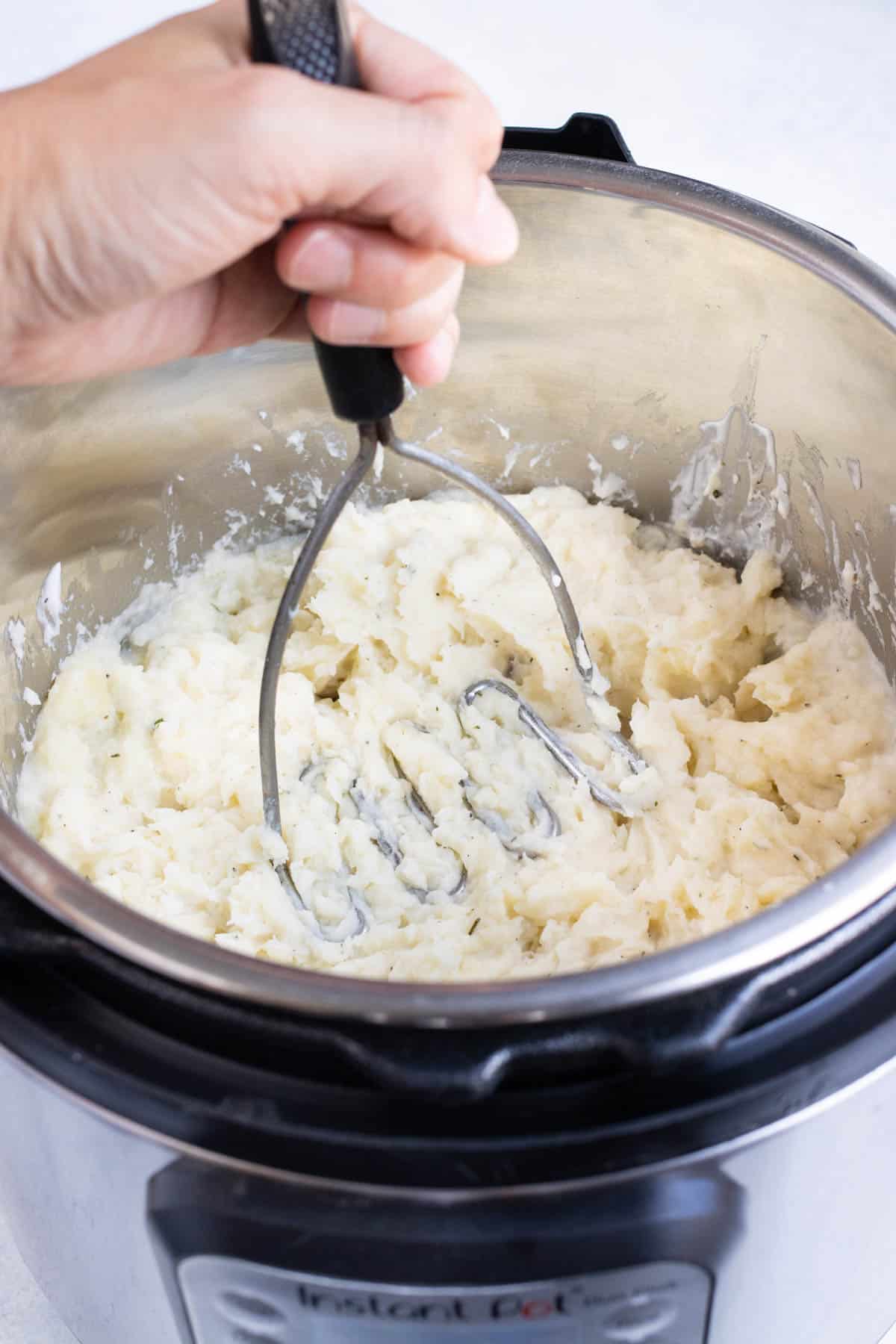 A potato masher mashes the cooked potatoes.