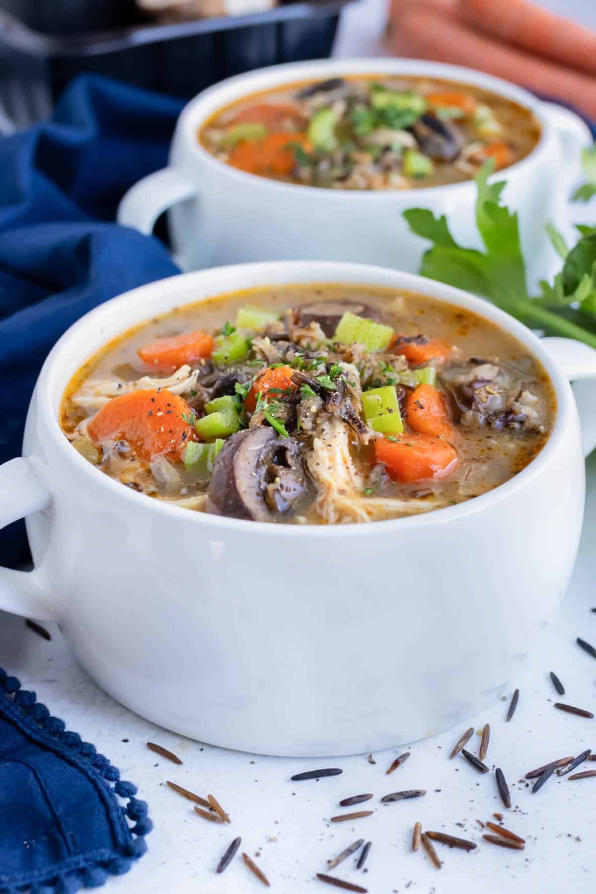 Two bowls of instant pot chicken wild rice soup are set on the counter before serving as a main dish.