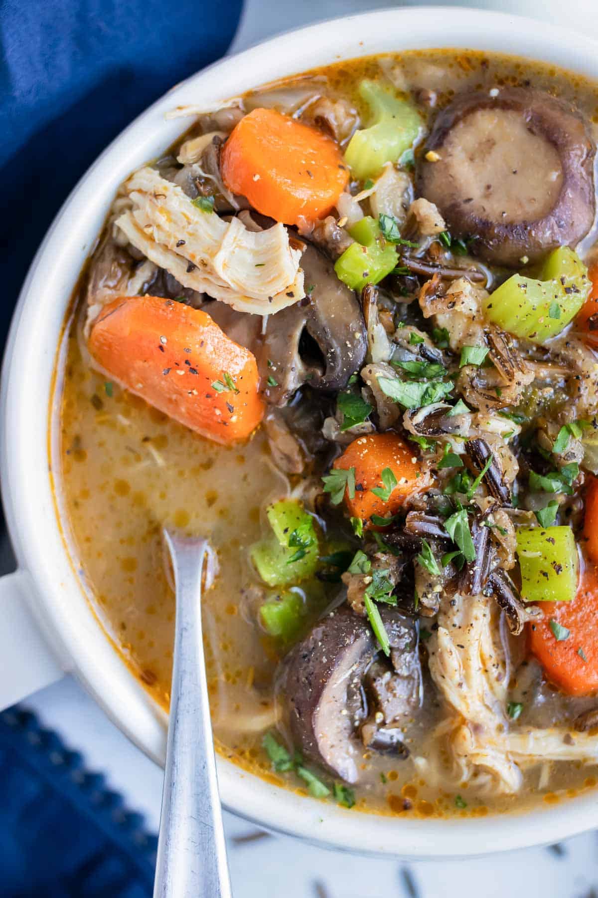 A white bowl is loaded with instant pot chicken wild rice soup for a dairy-free meal.