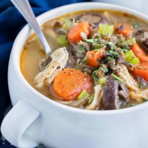 Easy pressure cooker soup is served with a spoon in a white bowl.