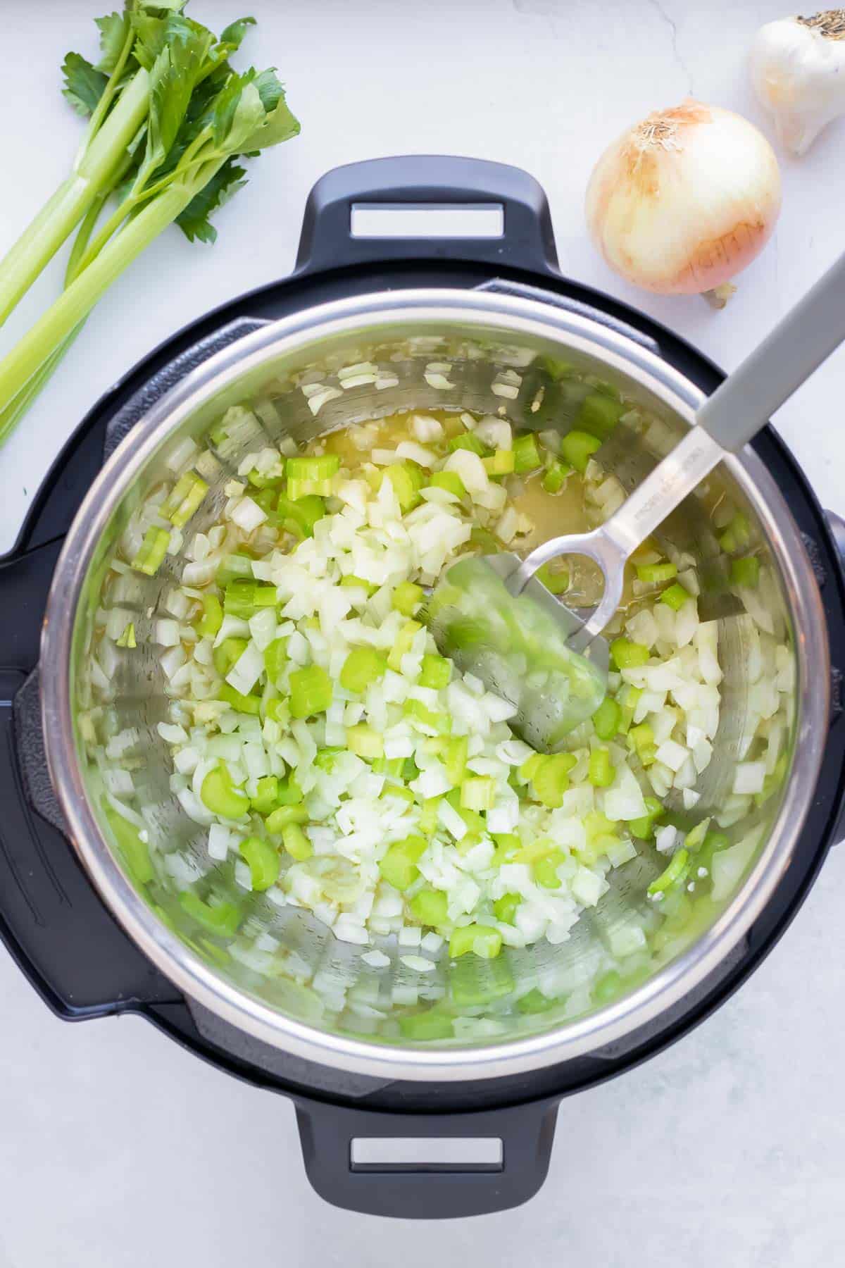 Onions and celery are added to the instant pot.