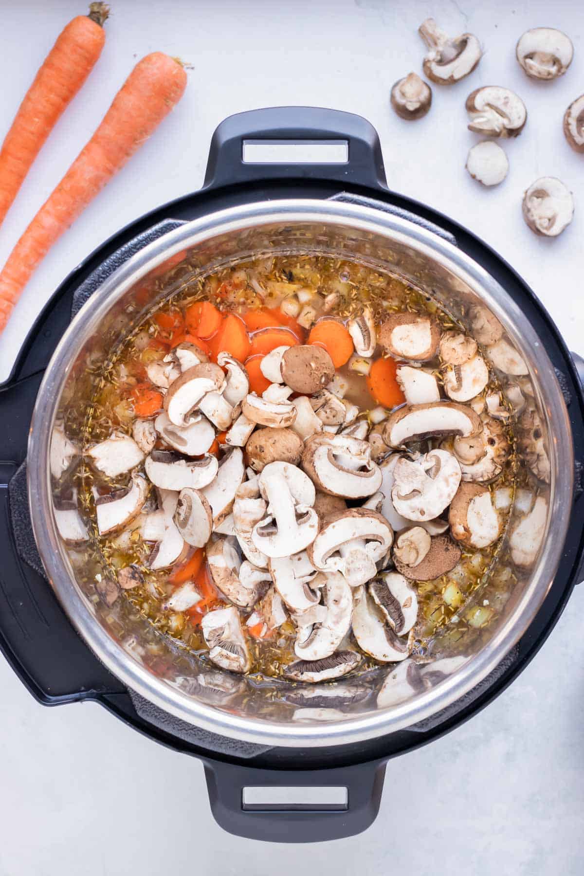 Mushrooms and carrots are added to the pressure cooker