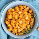 A serving bowl full of butternut squash that has been baked in the oven for a healthy Thanksgiving side dish recipe.