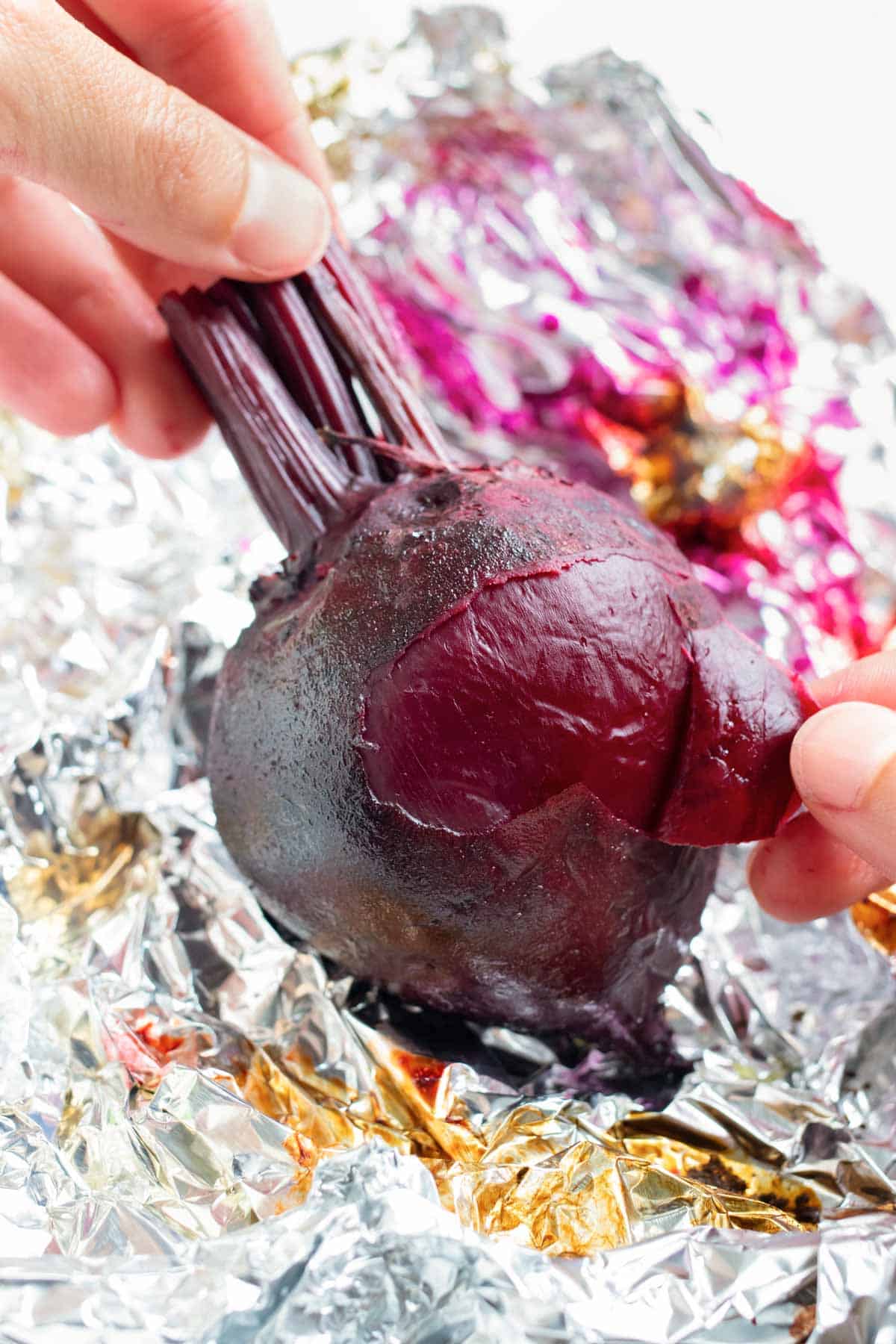 Using your fingers, easily peel back the skin on the roasted beets.