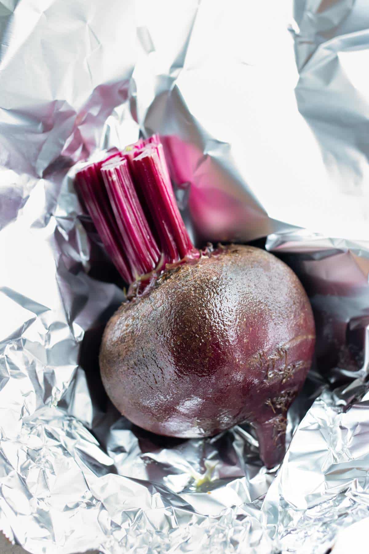 Oil covered beets are wrapped in foil before roasting.