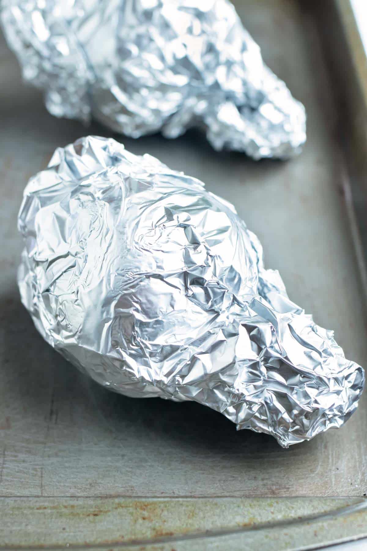 Beets are wrapped in foil and roasted in the oven on a baking sheet.