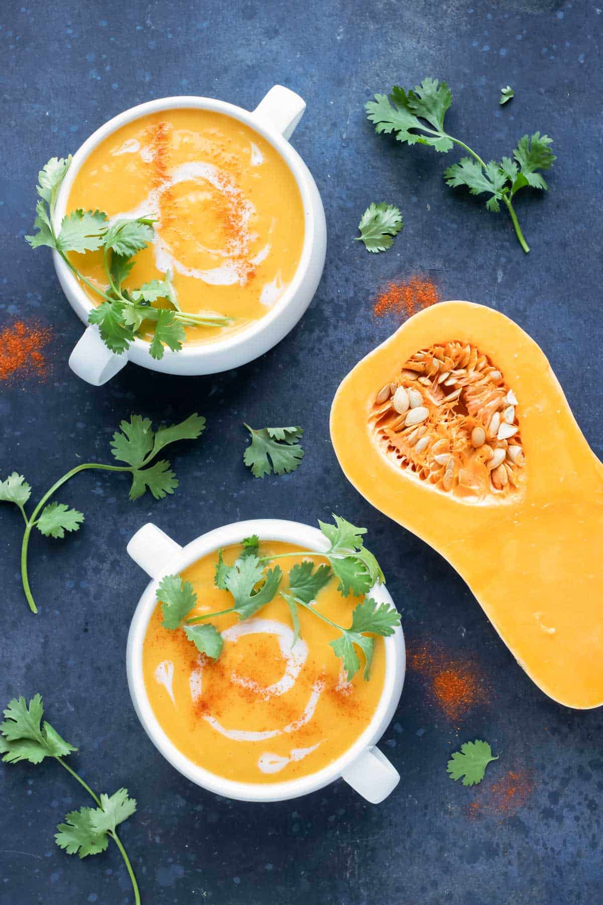 A healthy Whole30 butternut squash soup recipe with coconut milk in two bowls.