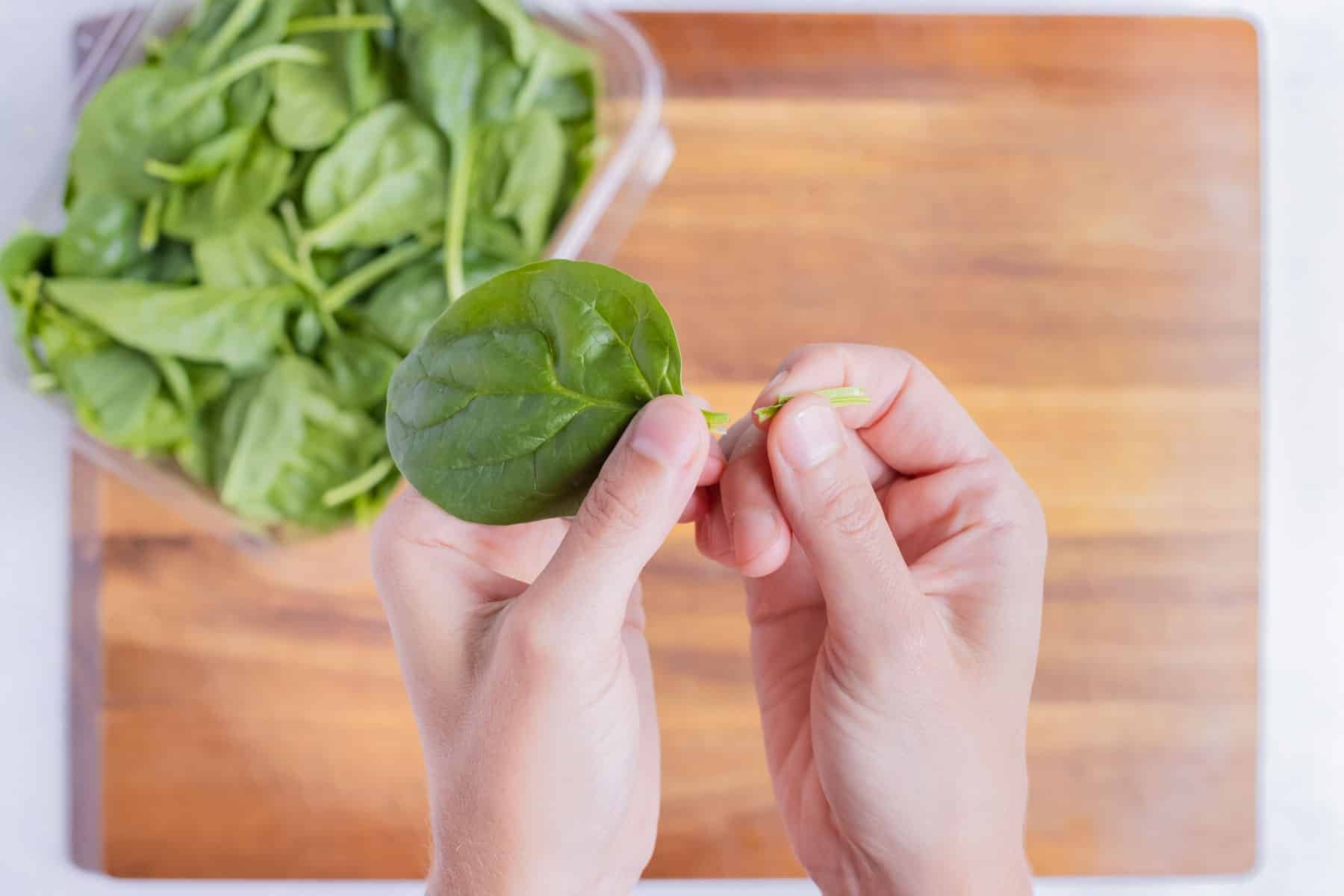 The stems are taken off the spinach leaves.