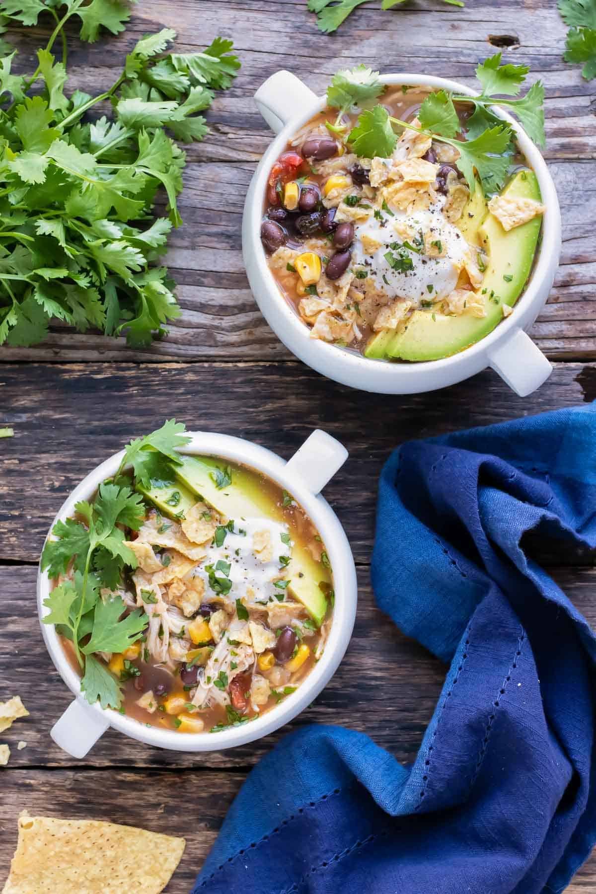 Two bowls of a chicken tortilla soup recipe that was made in the slow cooker.