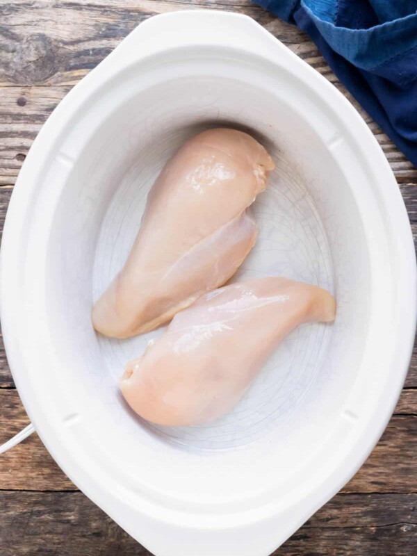 Chicken breasts are placed in a crockpot.