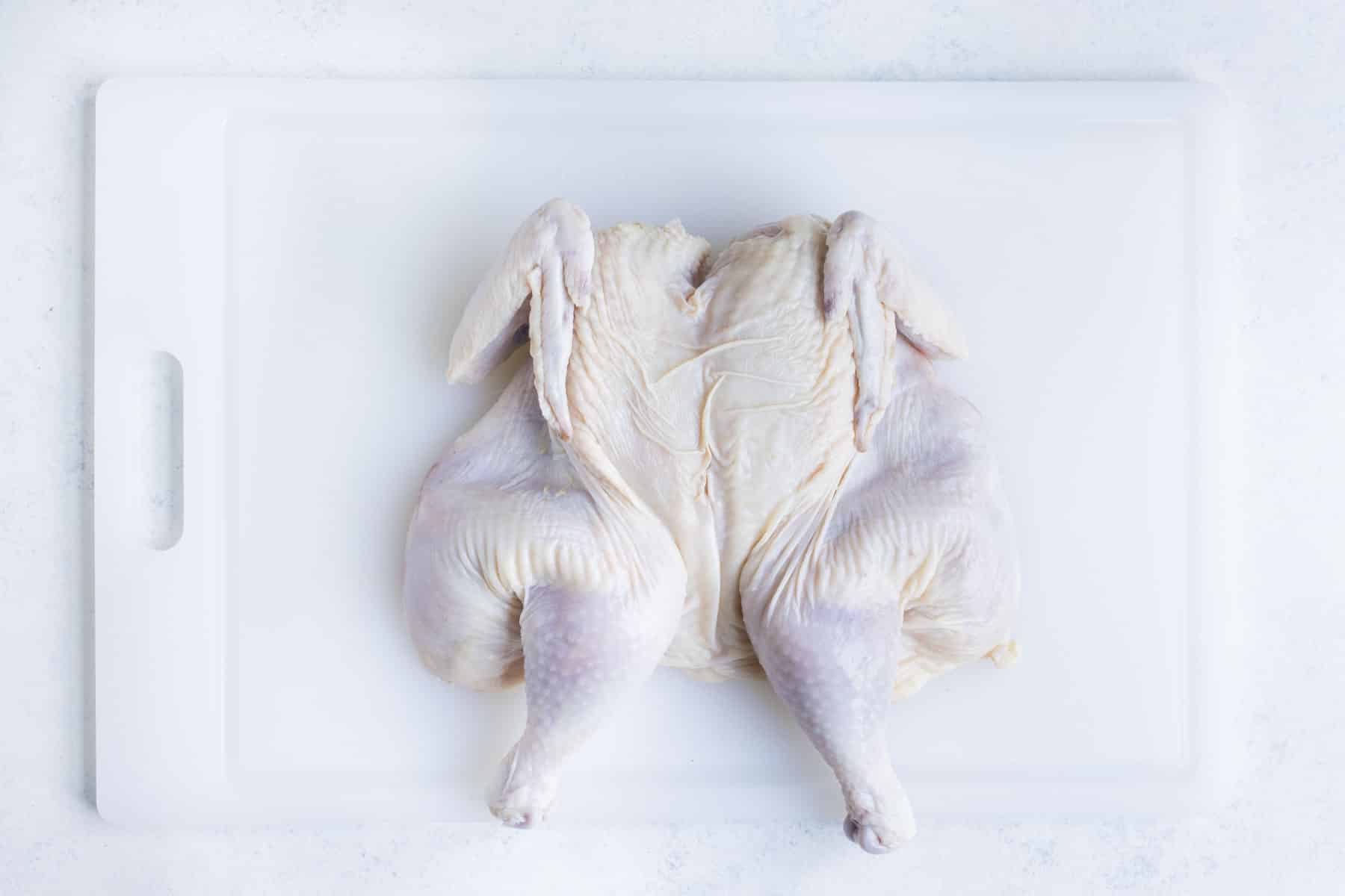 A spatchcocked chicken is ready to season.