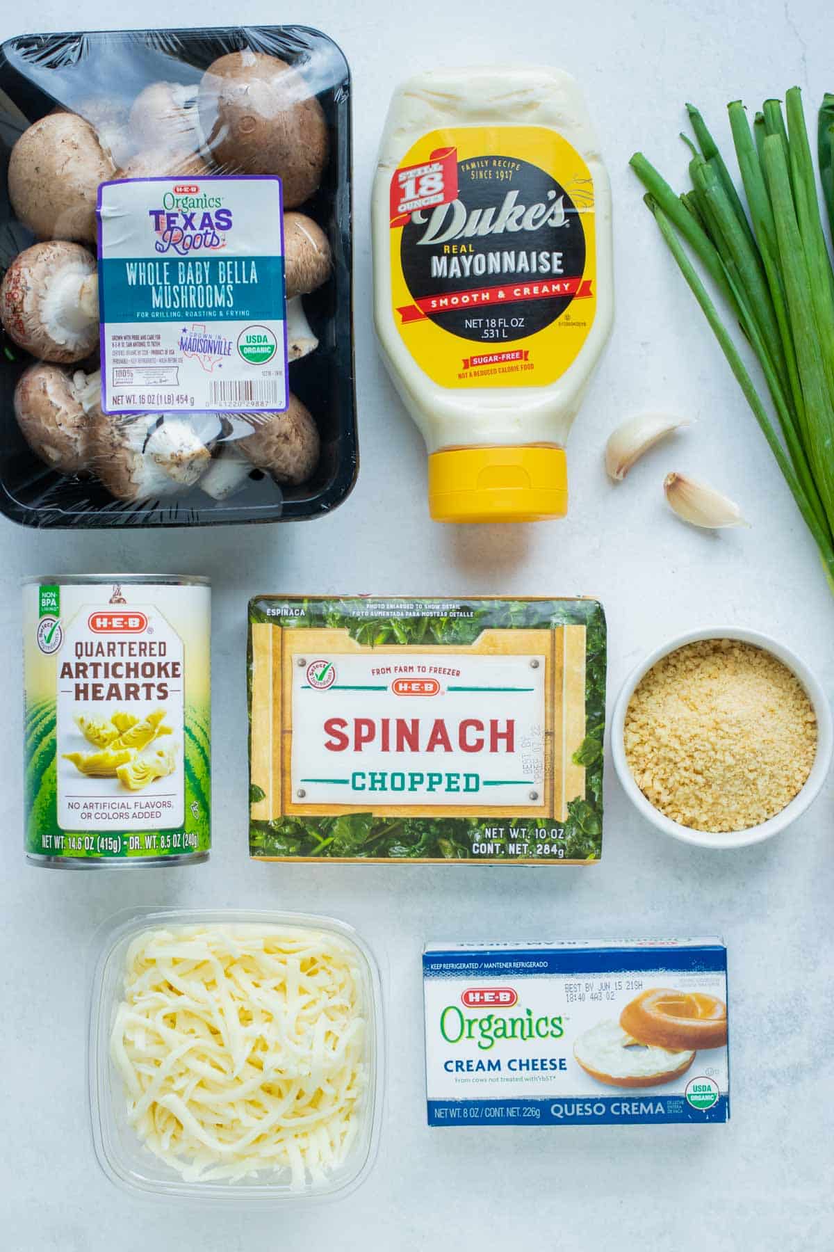 Frozen spinach, mushrooms, mayo, cream cheese, mozzarella and parmesan cheese, spices, breadcrumbs, green onions, and canned artichokes are the ingredients for this recipe.
