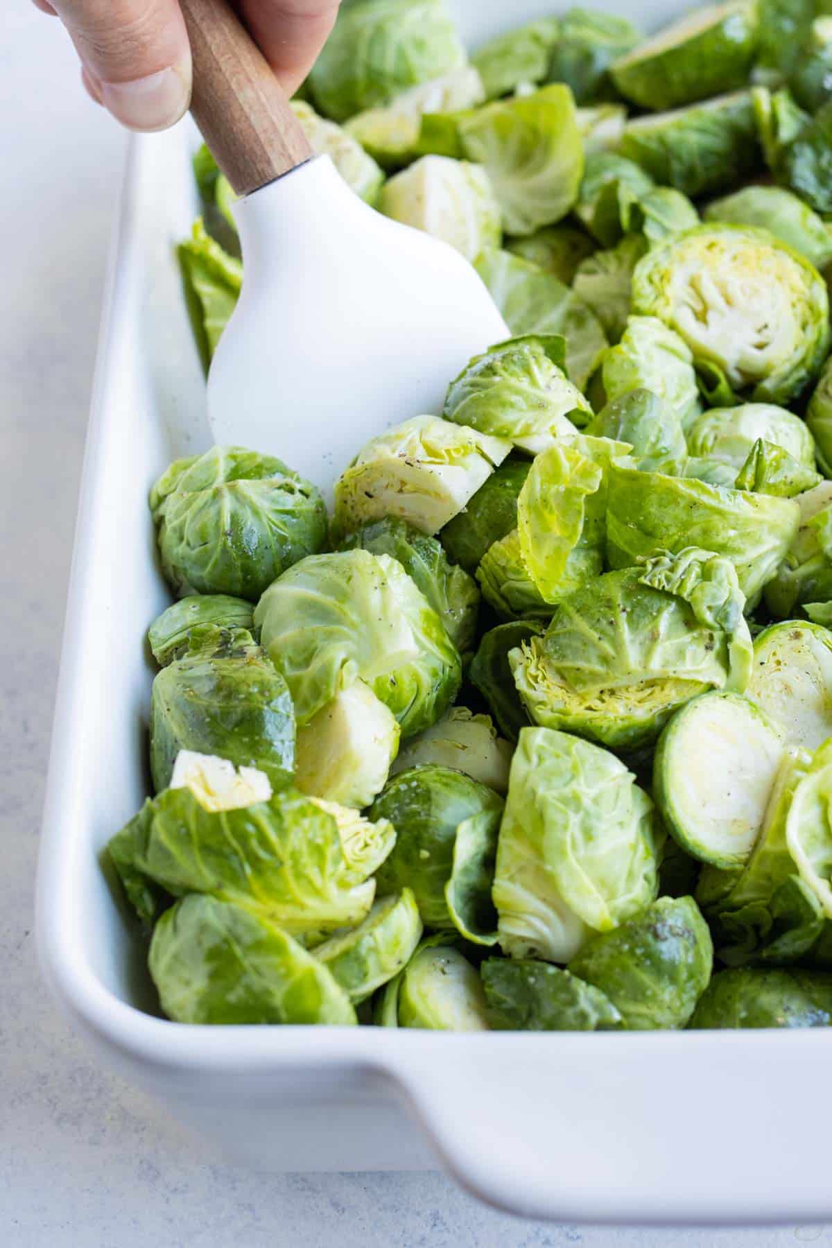A spatula stirs roasted Brussels sprouts.