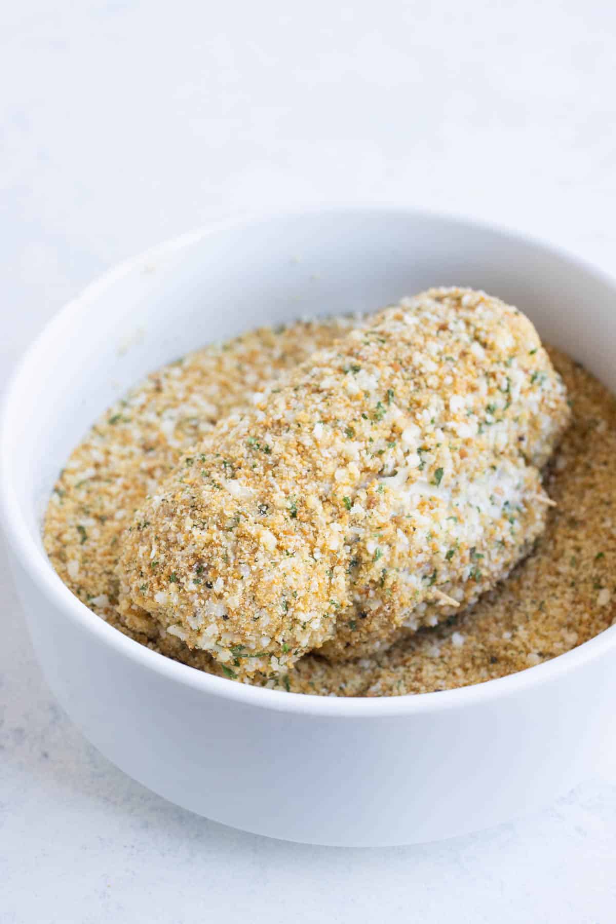Chicken rolled with ham and cheese is dipped in mayo then a breadcrumb mixture.