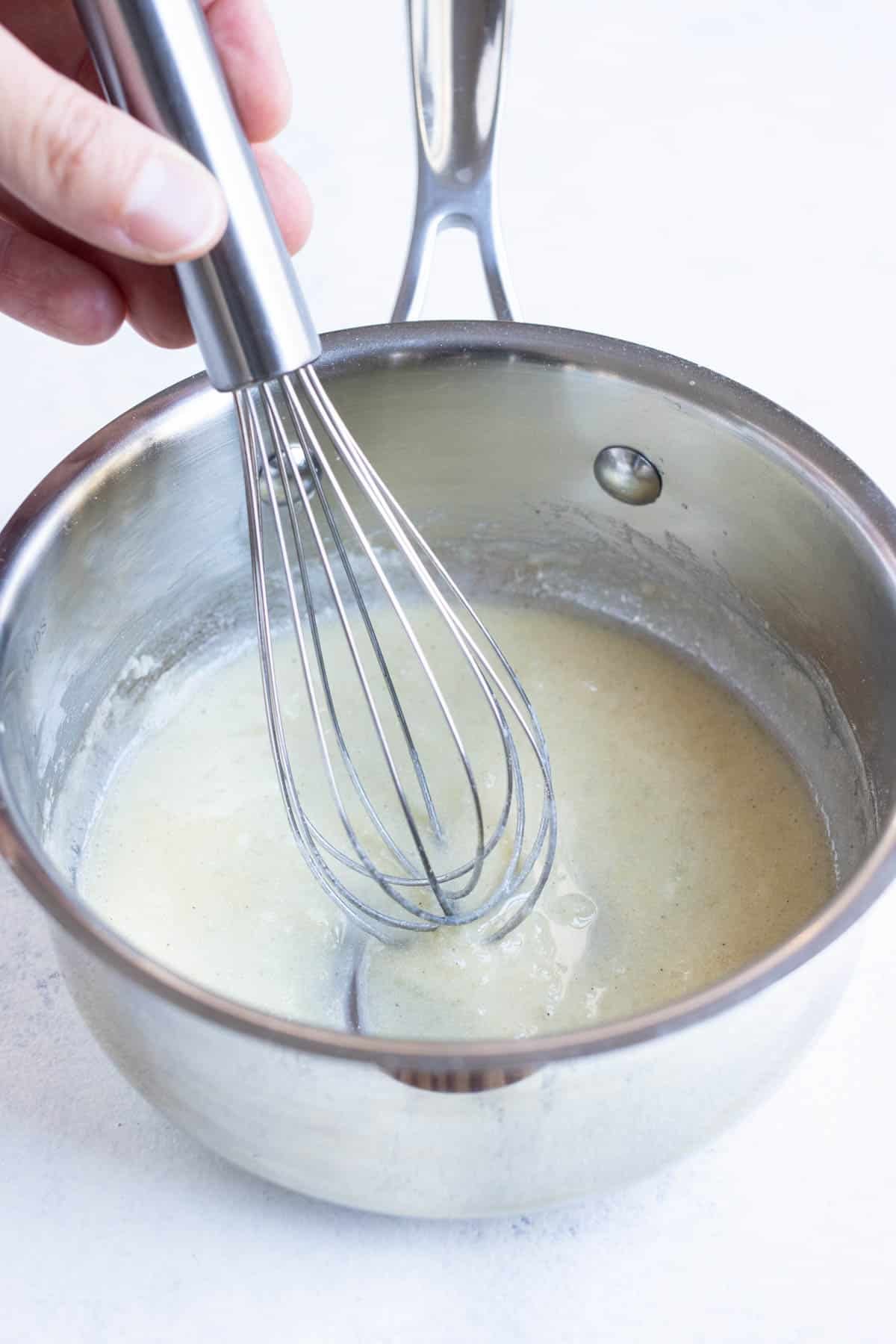 Milk is whisked into a roux.