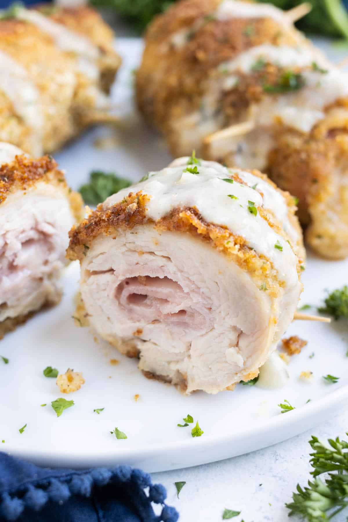 Ham and cheese are rolled up in chicken and then pan fried.
