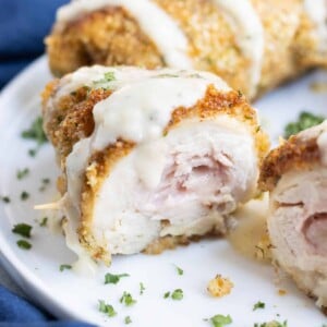 Creamy sauce is poured over crispy chicken roll ups.