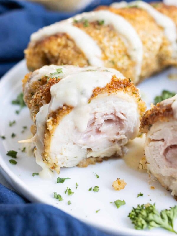 Creamy sauce is poured over crispy chicken roll ups.