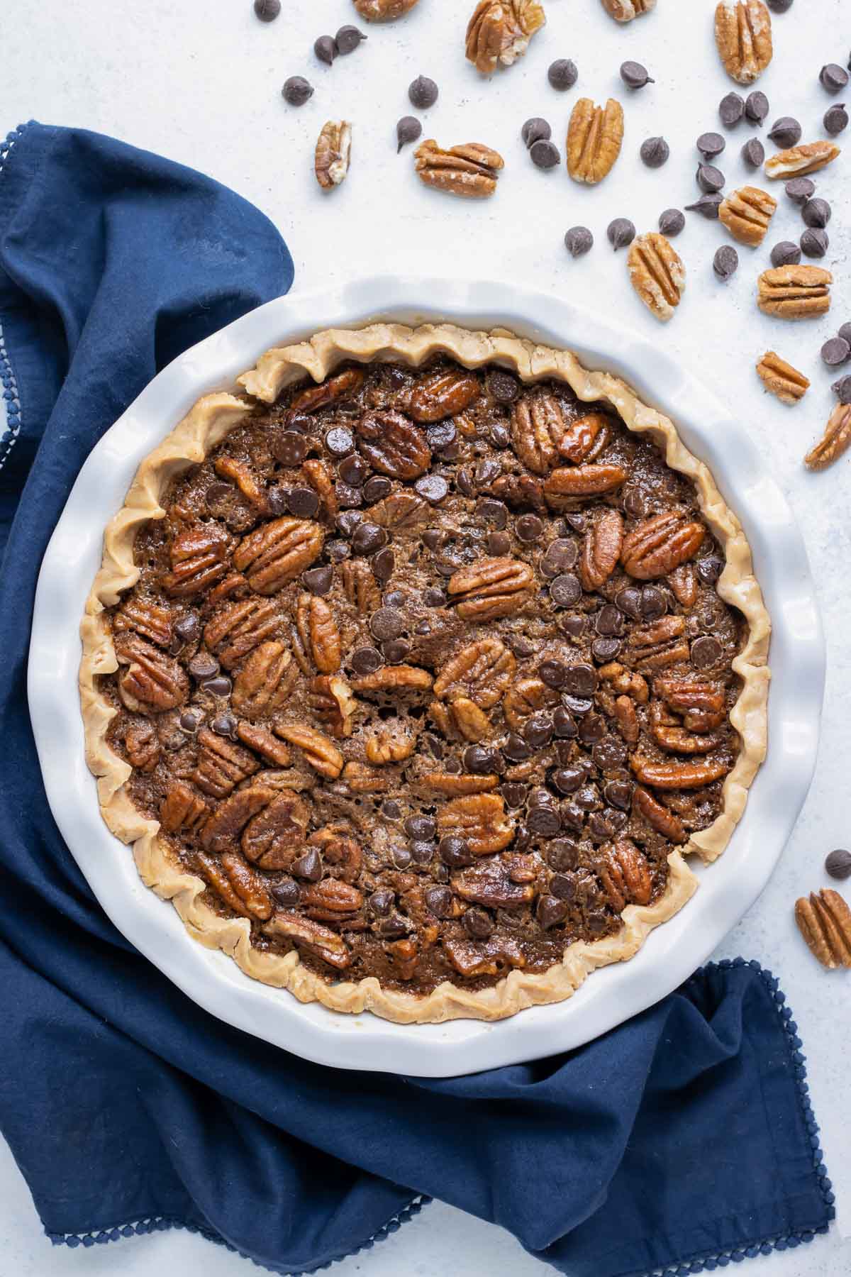 A whole chocolate pecan pie is shown on the counter.