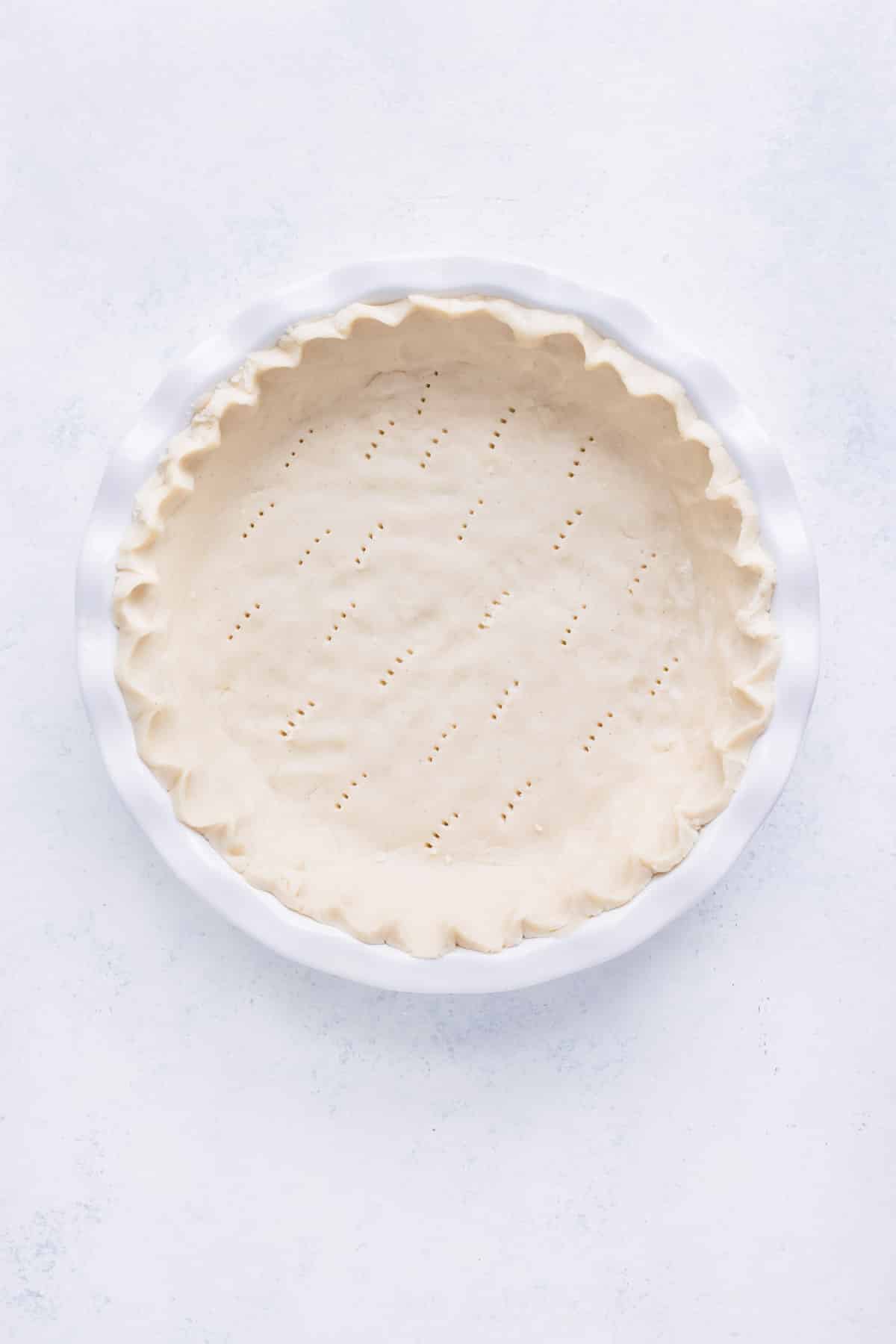 Pie dough is prepared in a pie dish.