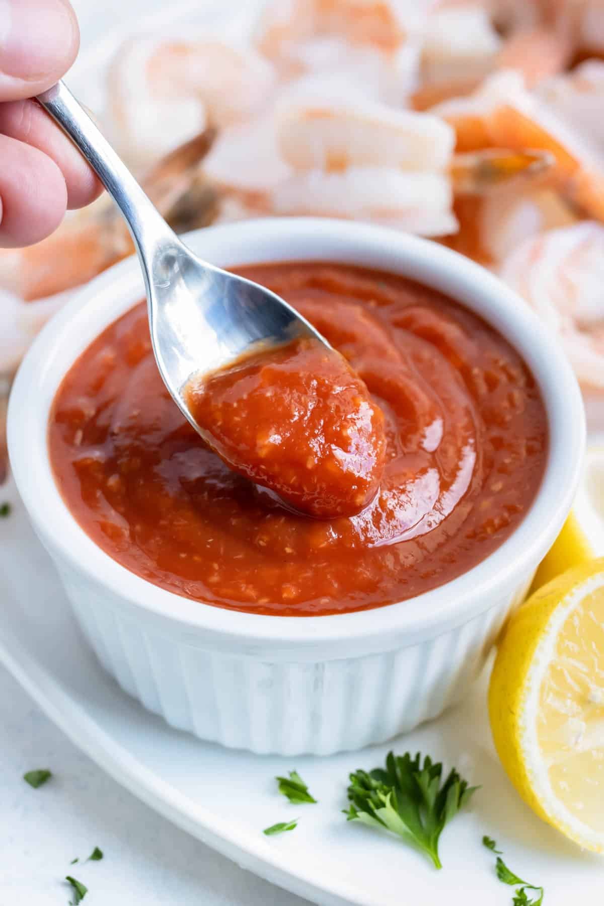 A spoon is used to serve this cocktail sauce appetizer.