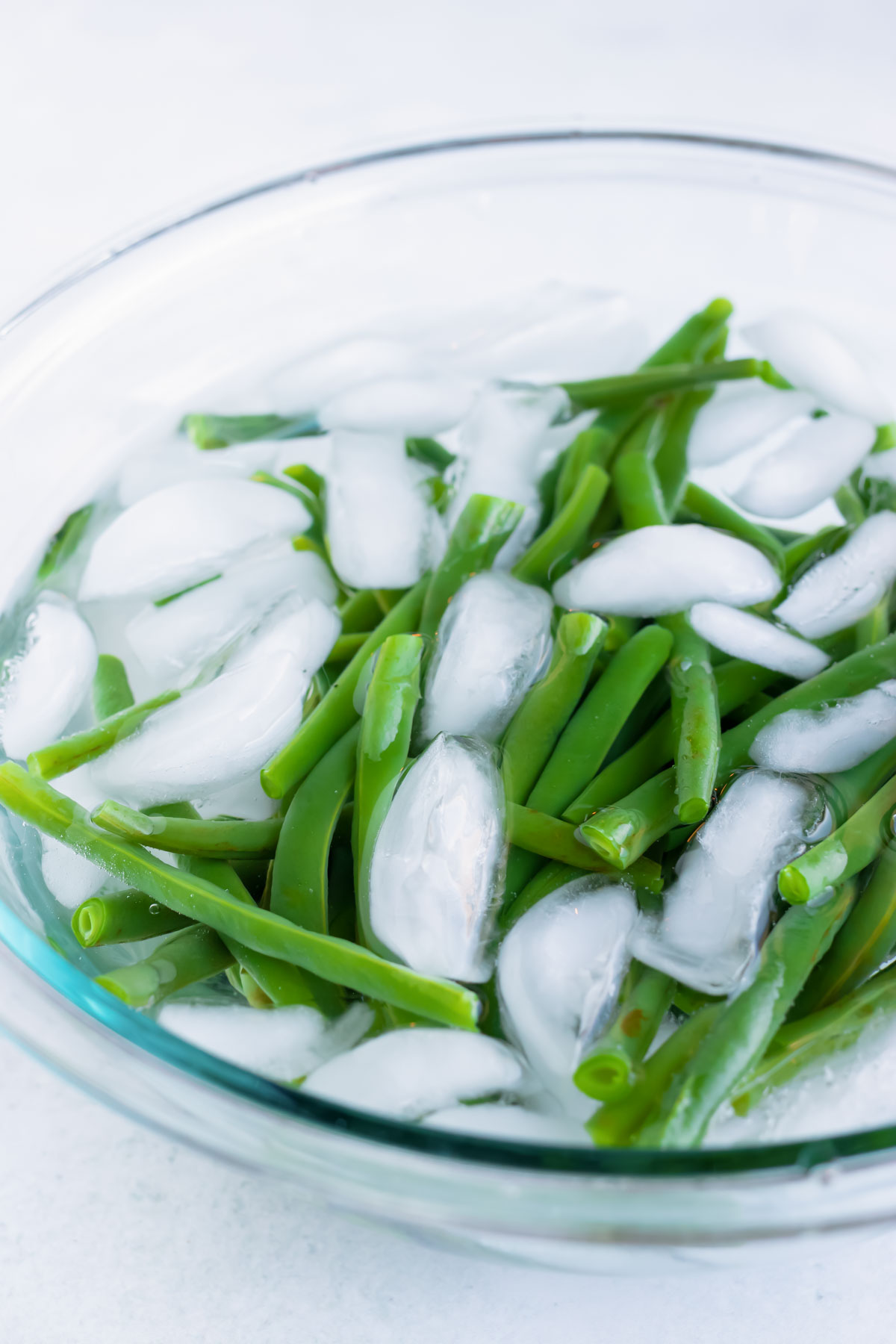 Blanching boiled green beans in an ice water bath.
