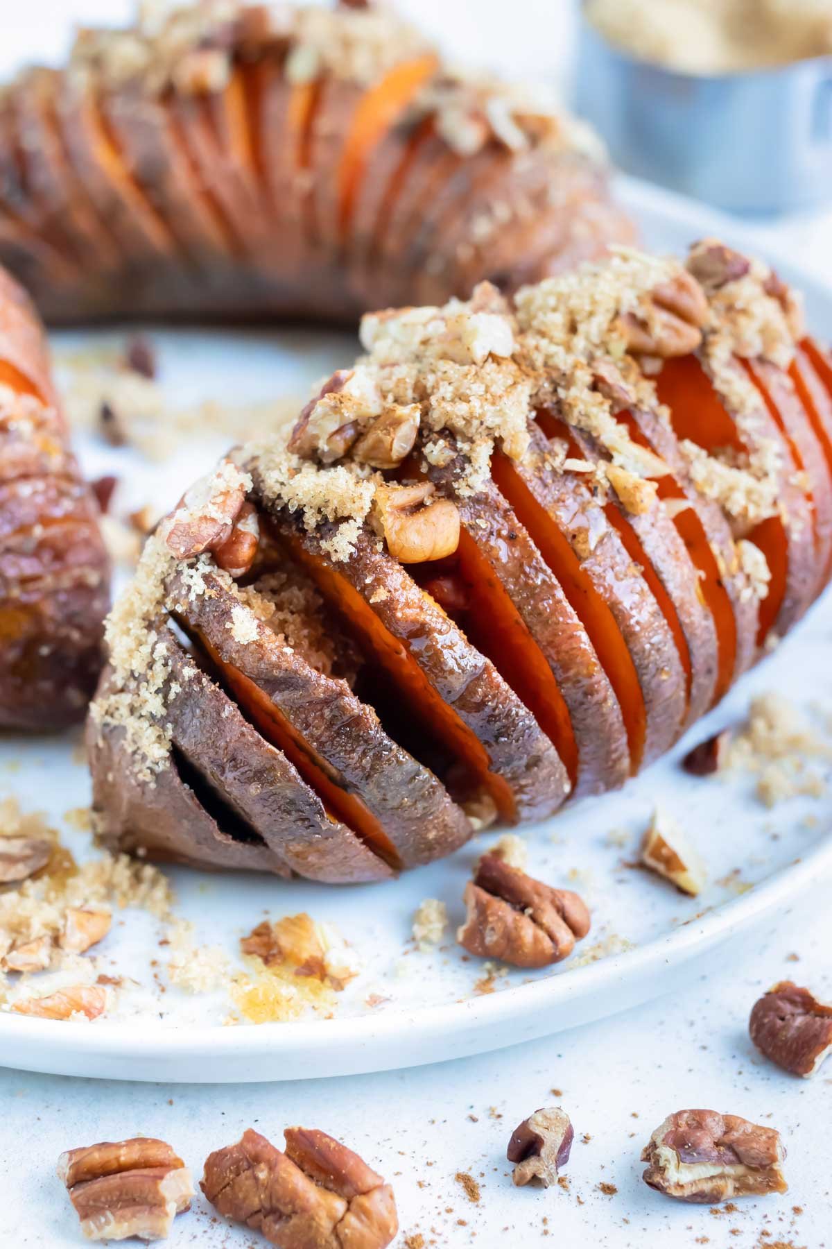 Crispy hassleback sweet potatoes are served on a plate for a vegetarian side dish.