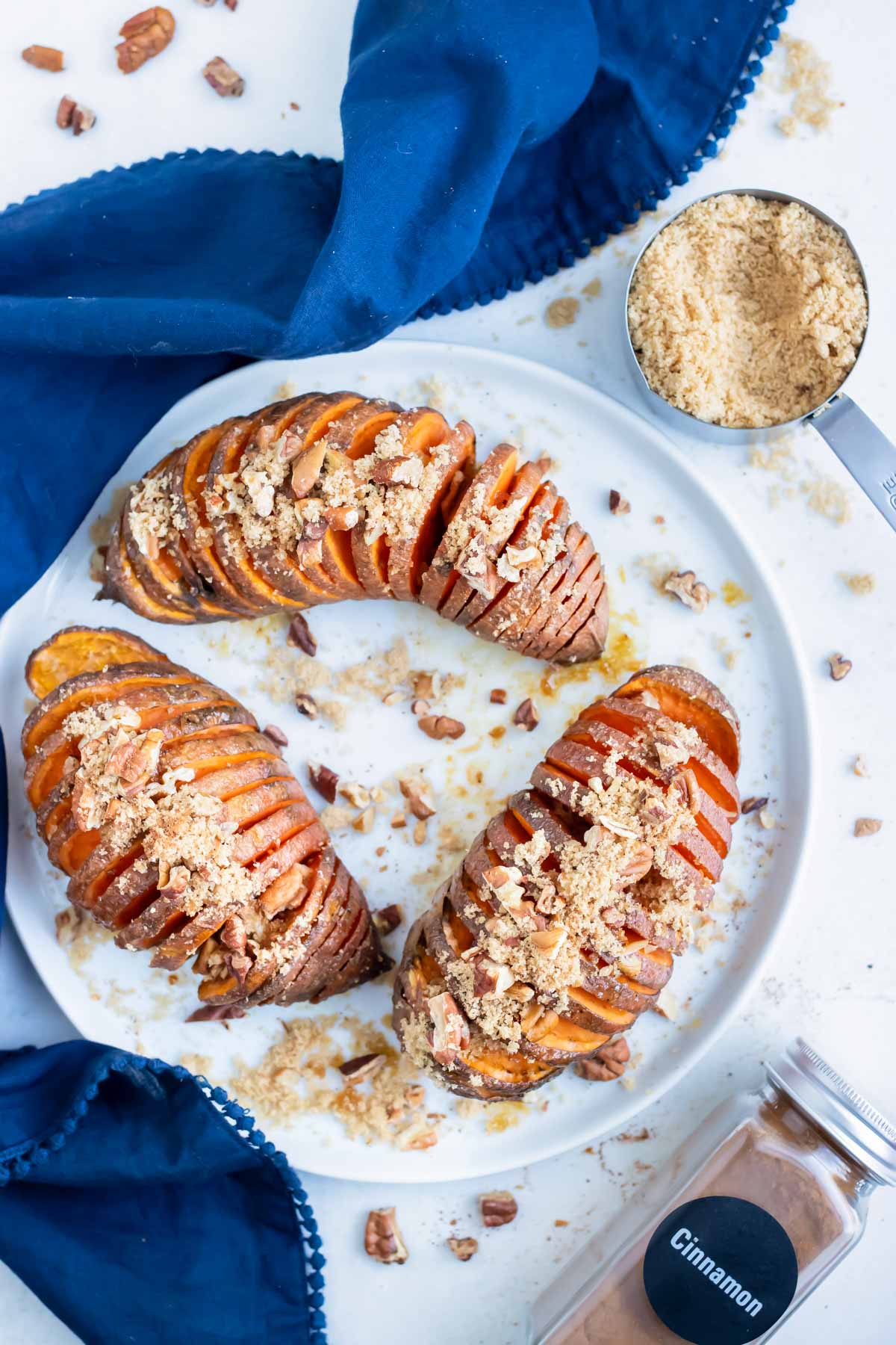 Hasselback Sweet Potatoes are sliced and roasted before being served on a plate.