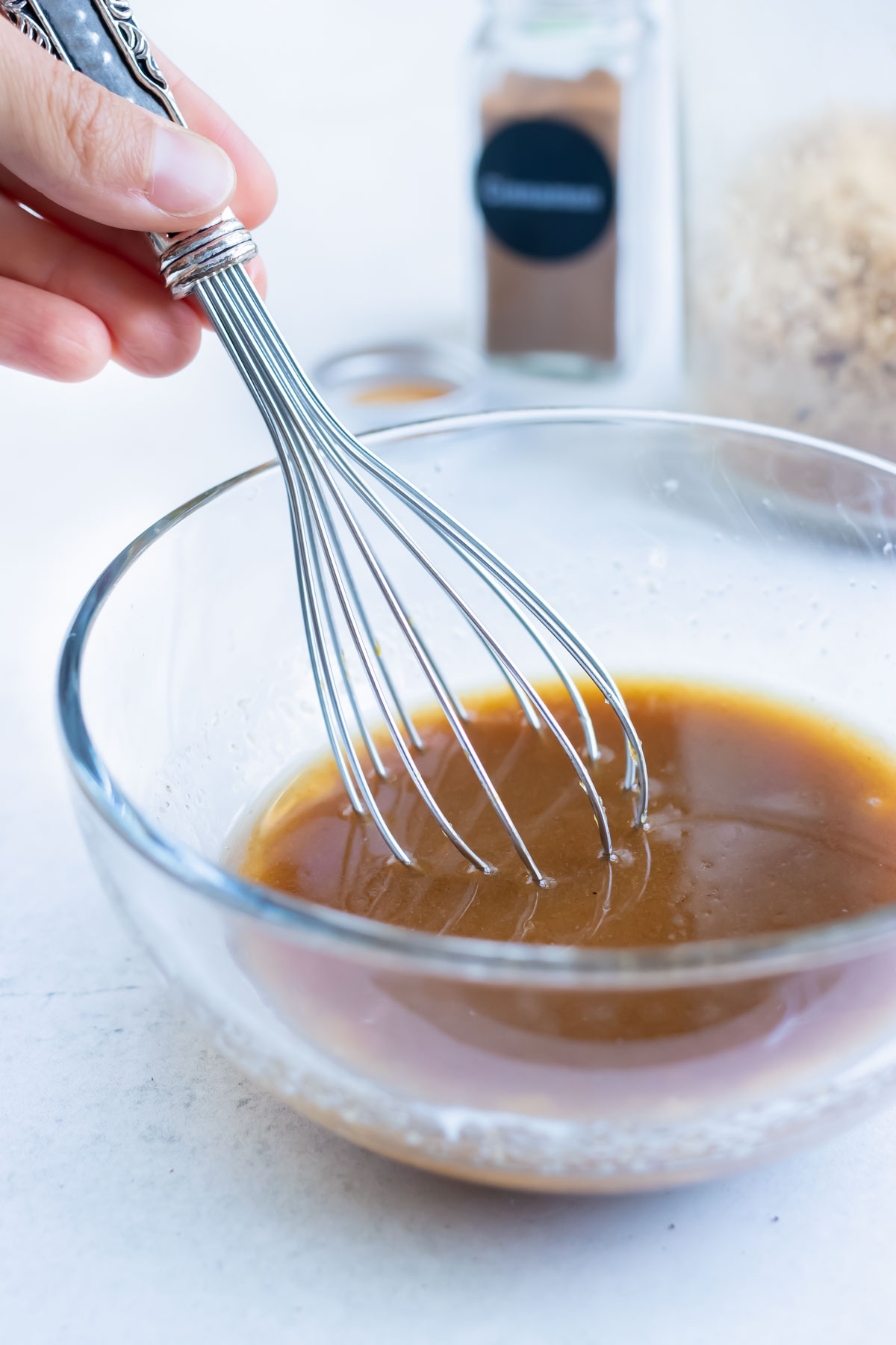 Melted butter, brown sugar, cinnamon, and oil are mixed together in a bowl.