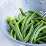 Boiled beans are drained using a colander.