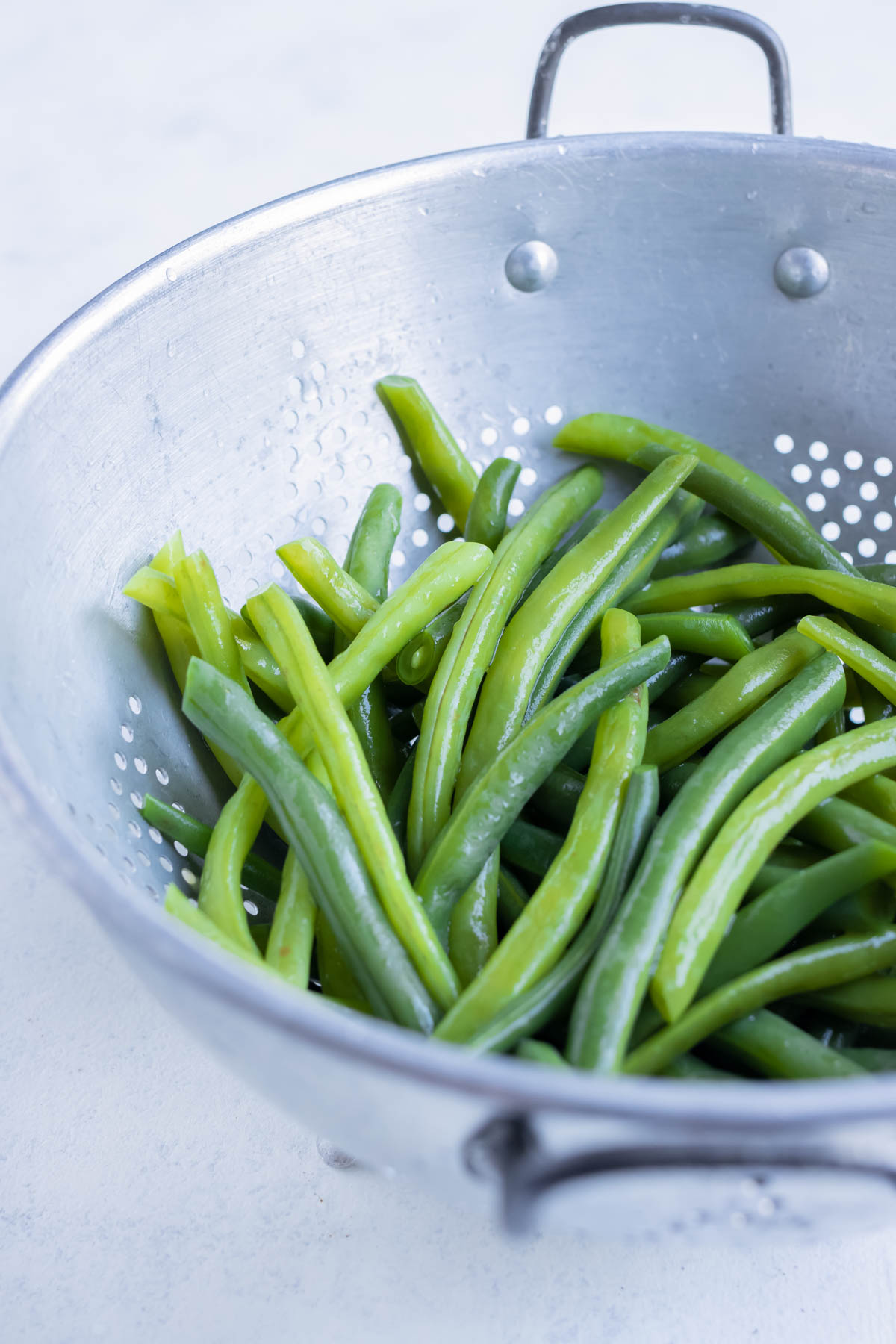Boiled beans are drained using a colander.