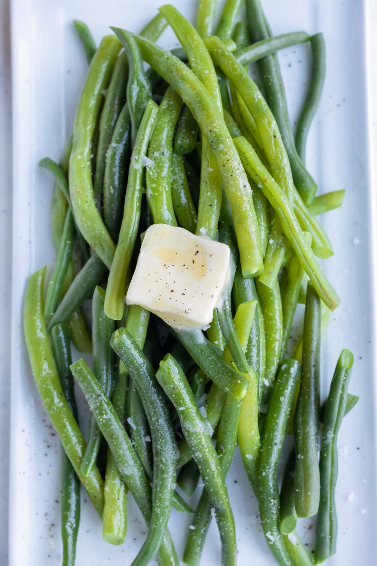Butter is placed on top of the blanched green beans.