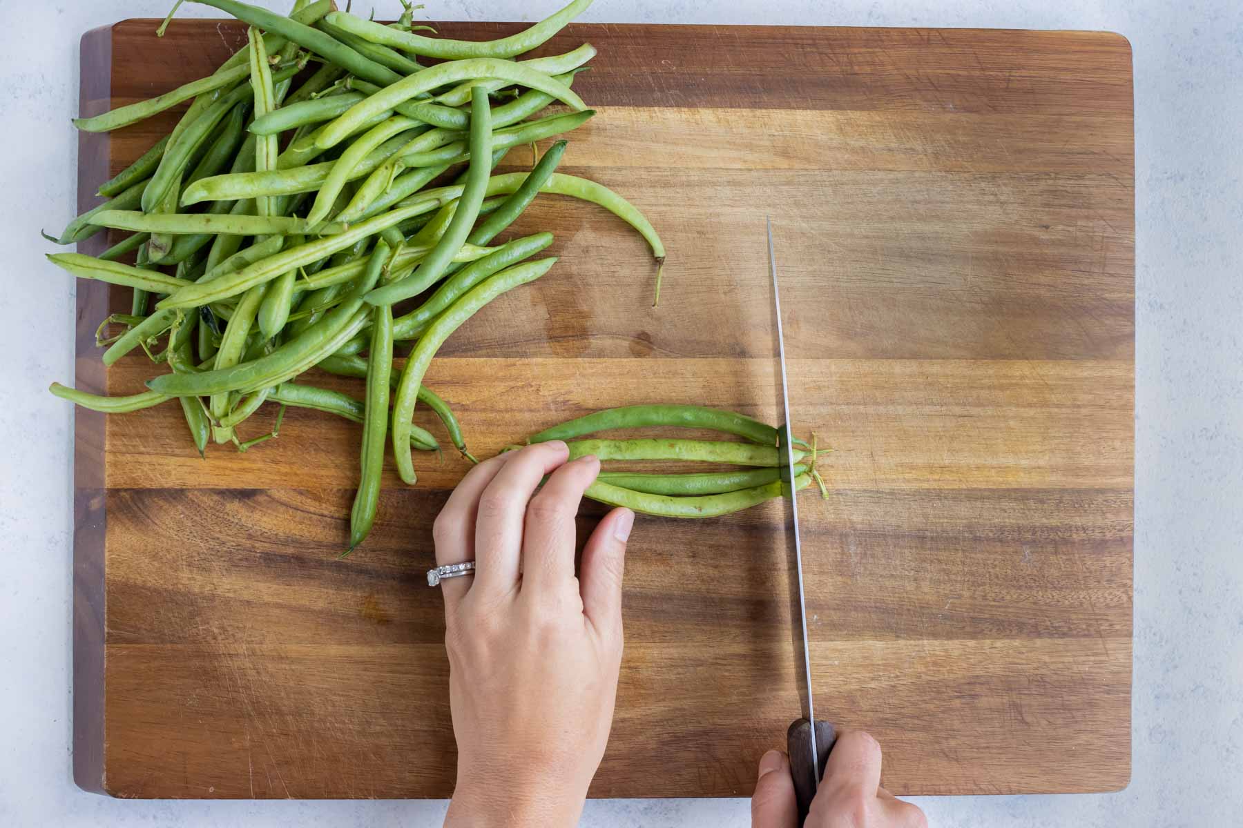Multiple green beans are prepared to be boiled.