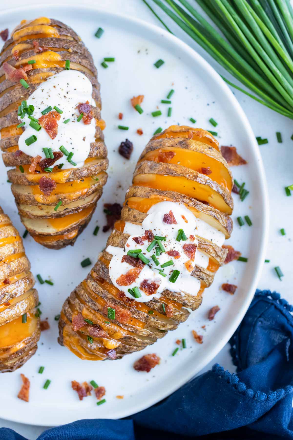 Stuffed hasselback potatoes are erved on a plate for a gluten-free side dish.