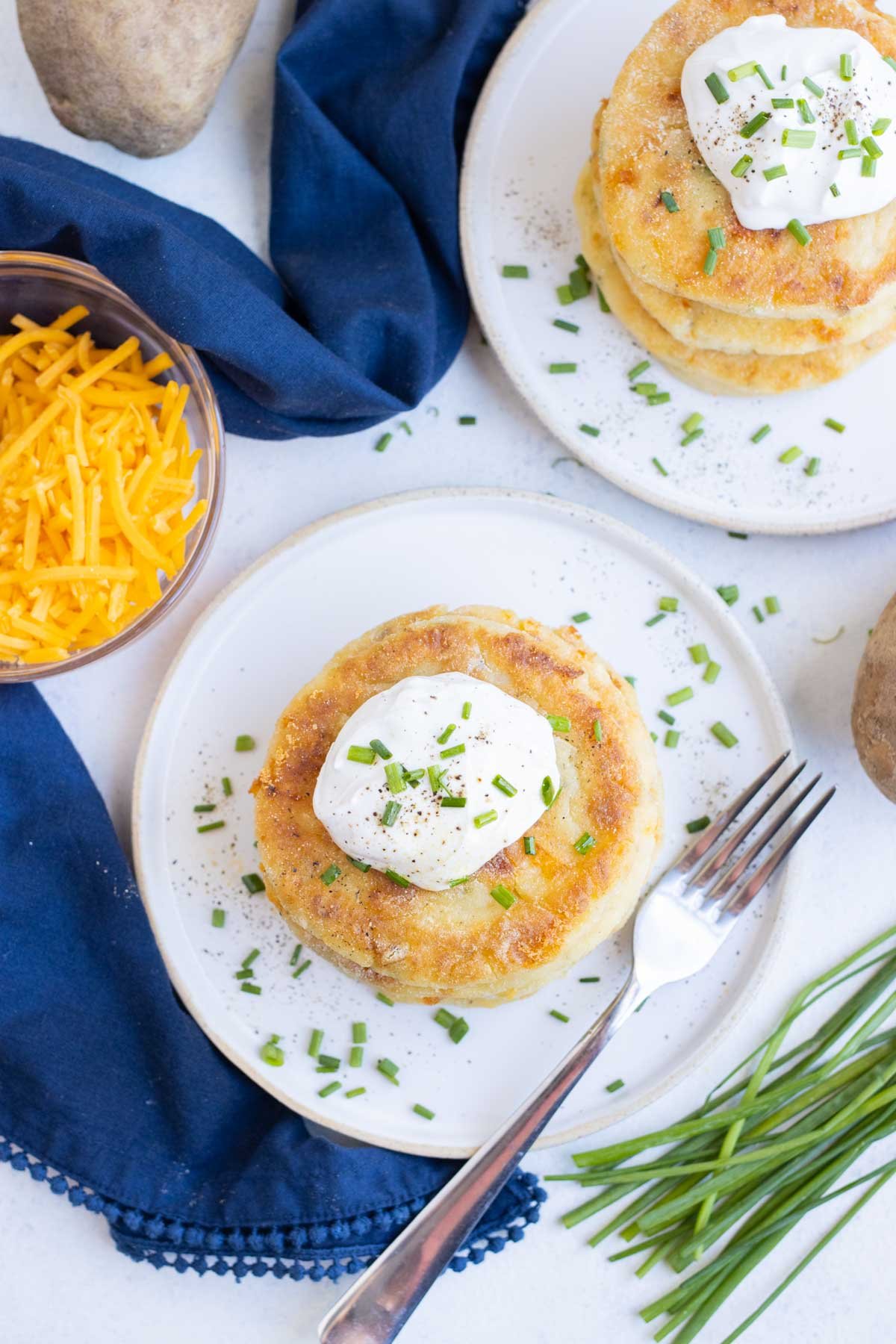 An overhead view of mashed potato pancakes on a plate.