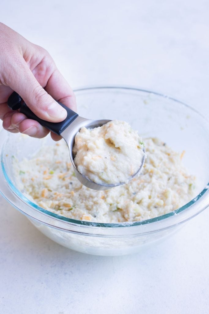 A scoop of potato pancake is removed from the bowl.