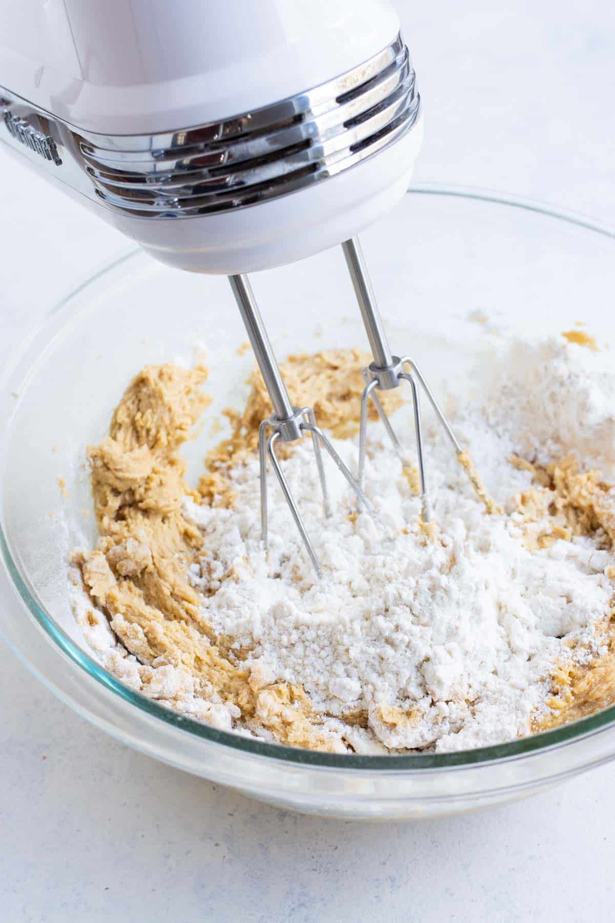 Dry ingredients are added to the sugar and peanut butter mixture.
