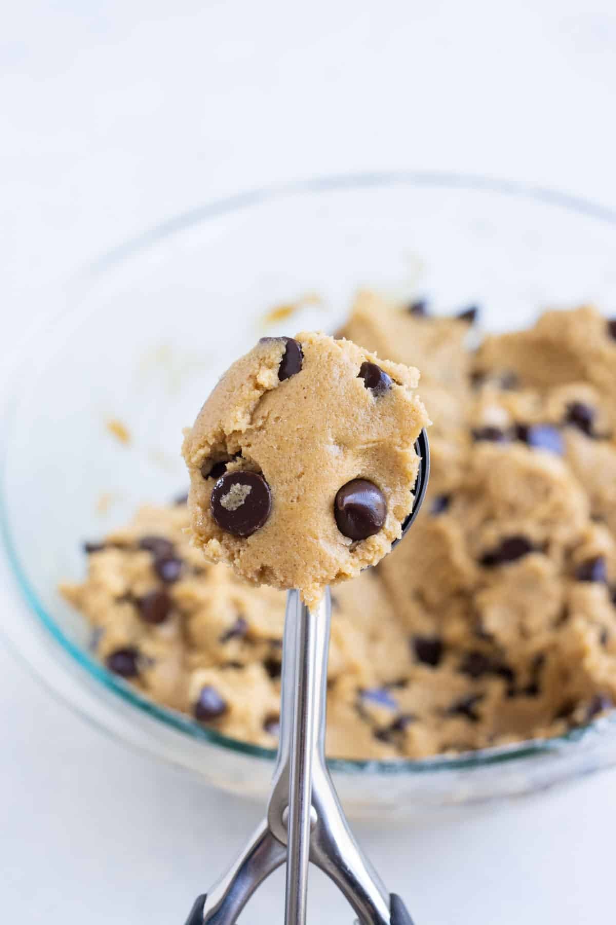 A cookie scoop measures out a cookie dough ball.