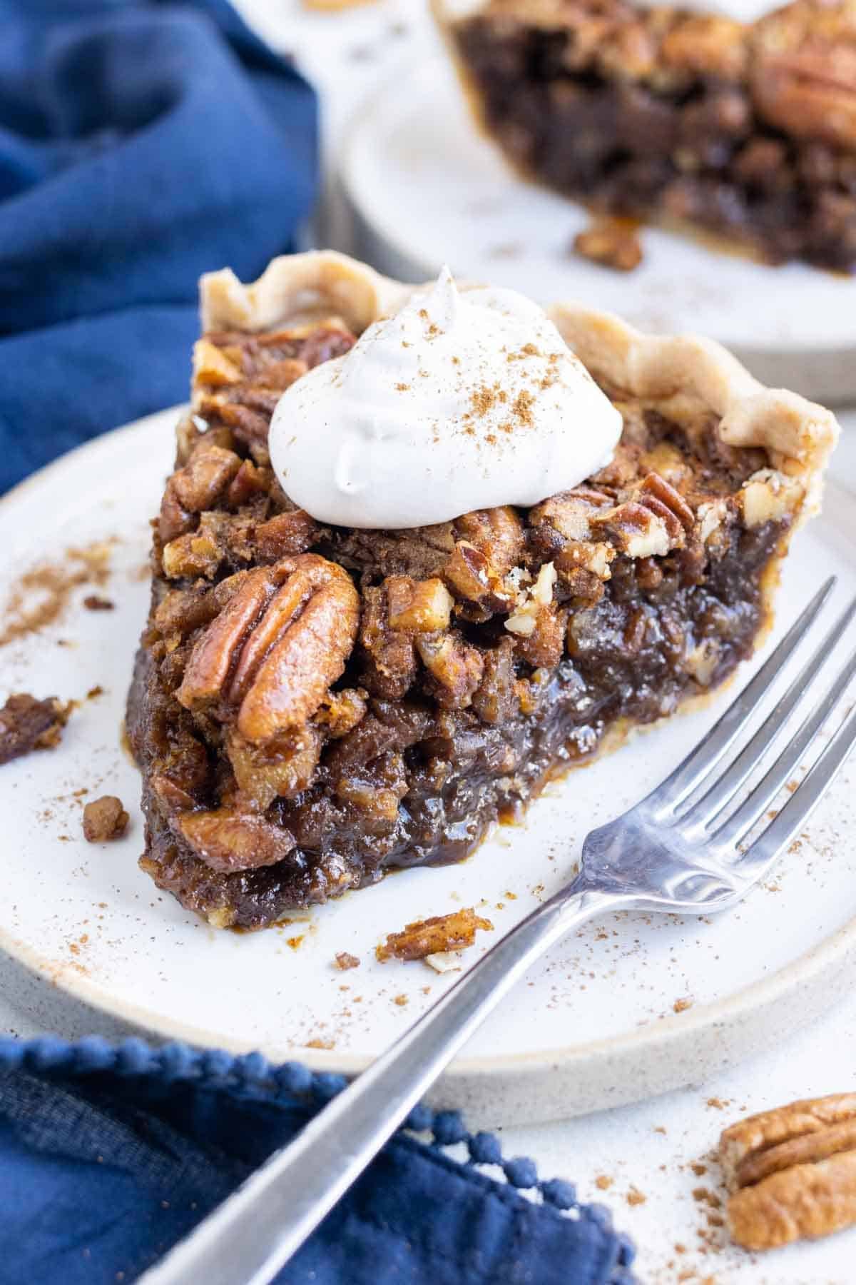 A slice of pecan pie is shown on a plate with a fork.