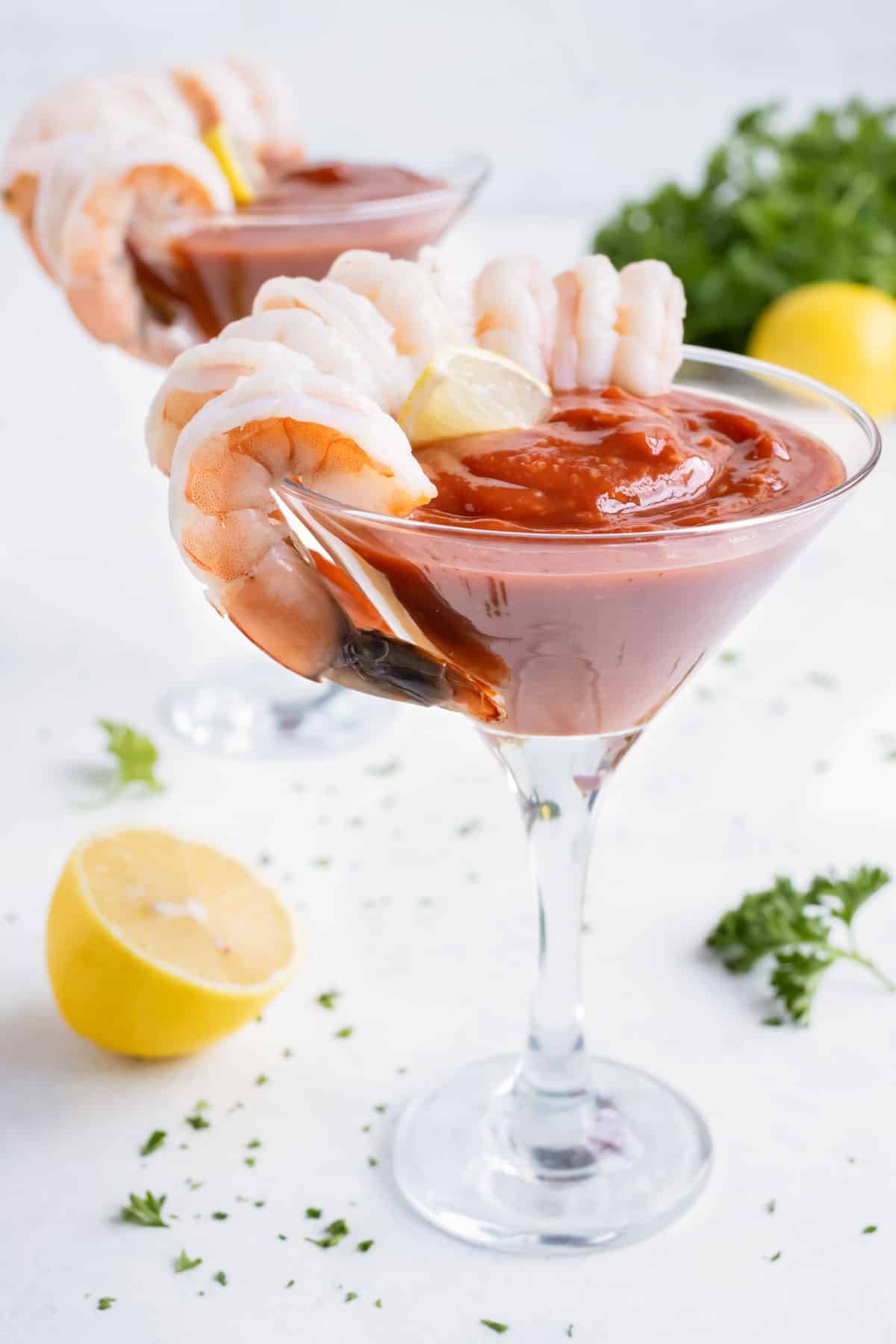 Shrimp is served with a glass of cocktail sauce.