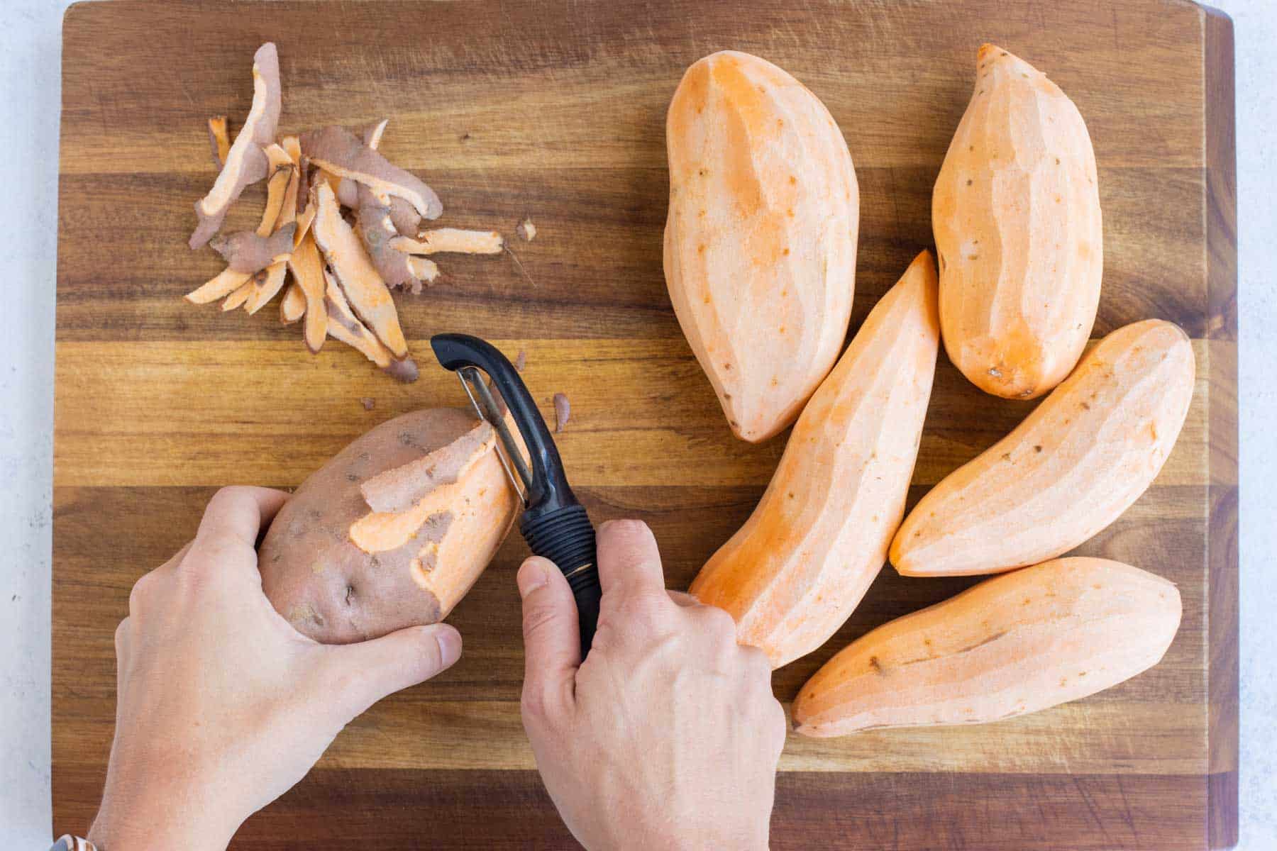 A vegetable peeler removes the skin from sweet potatoes.