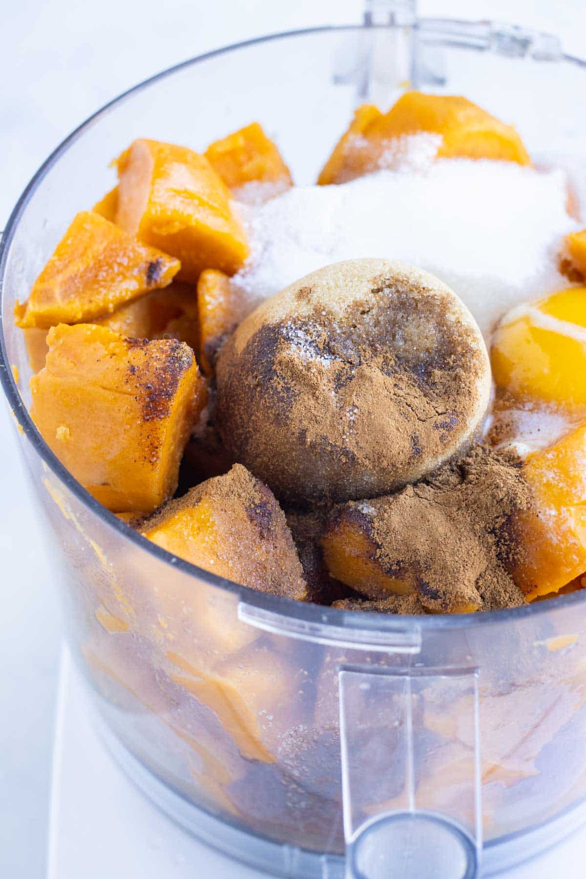 Boiled sweet potatoes are mixed in a food processor with cinnamon, sugar, eggs, and butter.