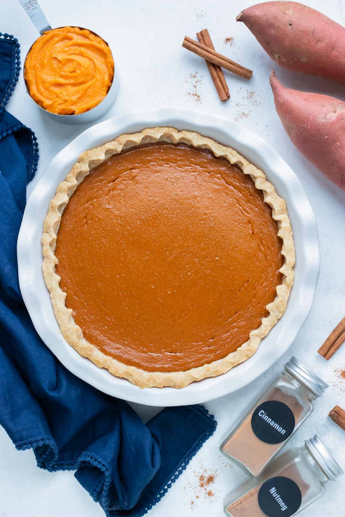 Southern sweet potato pie is served from a pie pan on the counter.