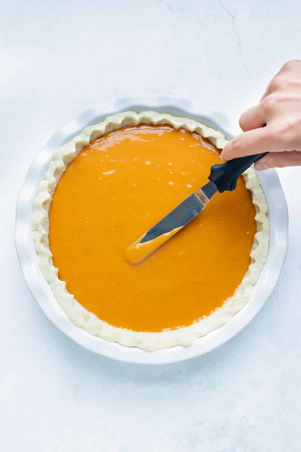Creamy sweet potato filling is added to the pie crust.