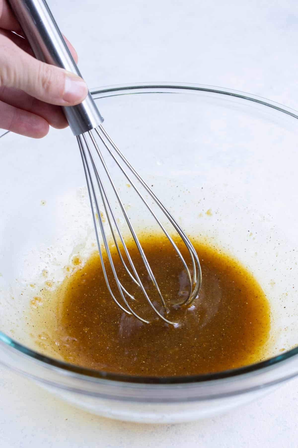 A sesame soy sauce is whisked in a bowl.