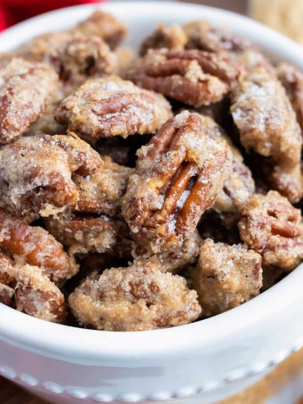 Cinnamon sugar pecans are in a white serving bowl for the holidays.
