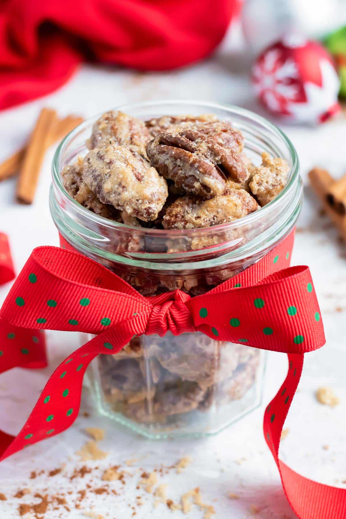 Candied pecans in a mason jar with a ribbon that are the best food gift for Christmas.
